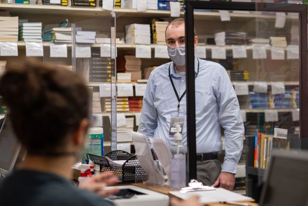 A photo of Kurt Mahnke (CAS’04) behind the counter at Barnes and Nobles at BU