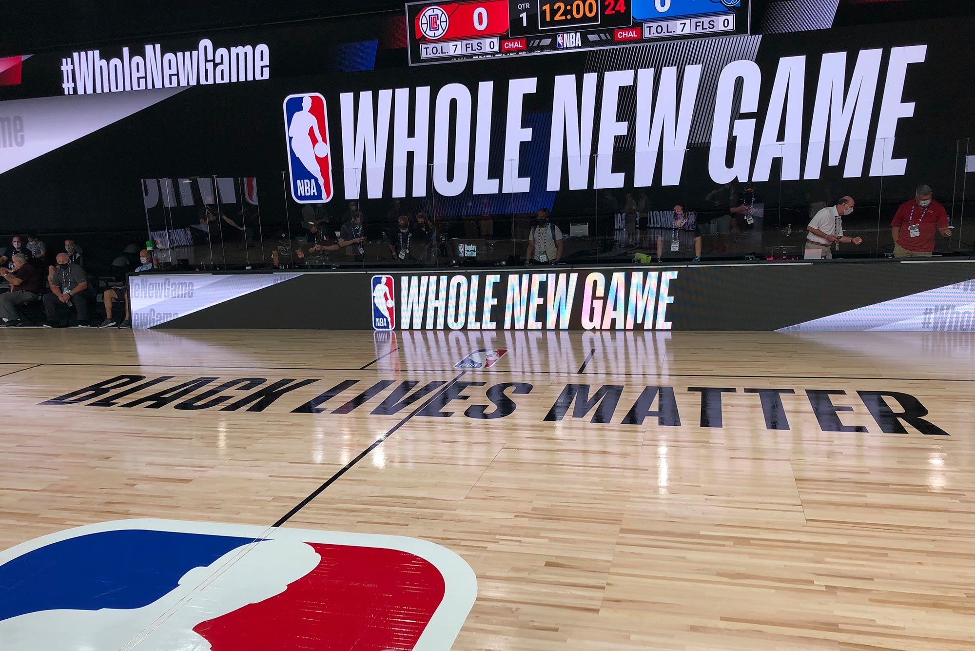 A basketball court is shown at the ESPN Wide World of Sports complex in Kissimmee, Fla., Tuesday, July 21, 2020. The NBA's marketing motto for the restart of the season at Walt Disney World is “Whole New Game,” which is written on a television screen and banner near the court. The court parquet floor reads "Black Lives Matter"