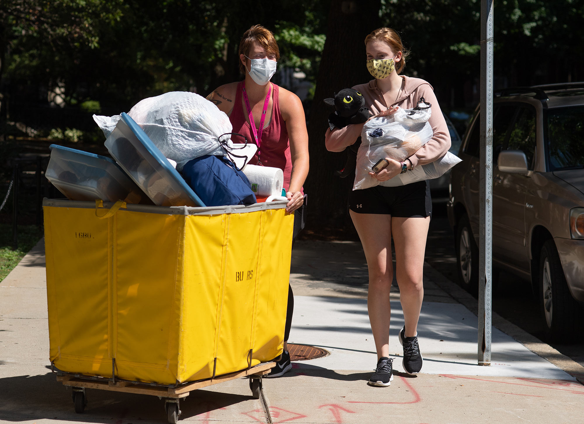 Elina Brooks (ENG’24), right, moves into Kilachand Hall with the help of her mom M.J. Brooks August 17. The two traveled from Annapolis. Both women wear masks and M.J. Brooks pushes a yellow cart of belongings while Brooks carries something.