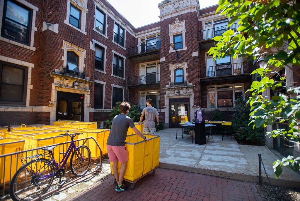 Students wait in line with yellow moving carts to claim their dorm keys at 518 Park Dr. during Boston University Charles River Campus Fall semester 2020 move-in