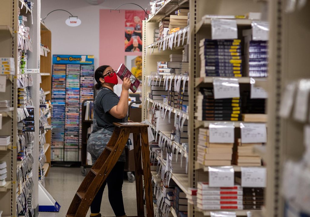 Bookseller Maria Cornier shelving books in the stockroom at BU