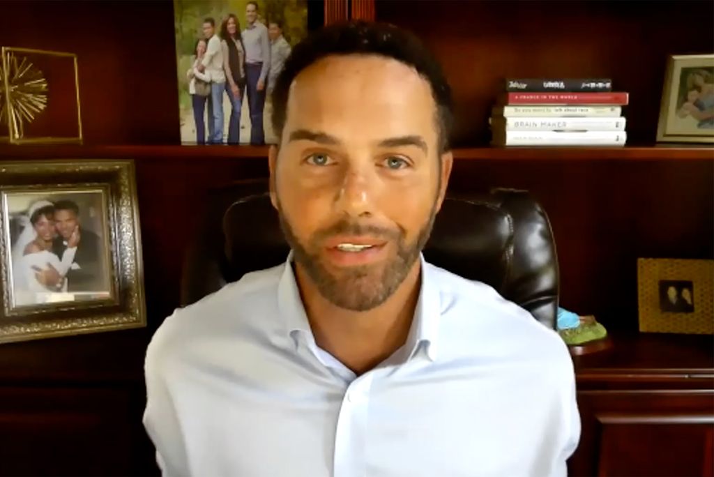 Screenshot of Steve Pemberton on a zoom call with Upward Bounds Summer 2020 Students. Steve wears a white collared shirt and a bookshelf with family photos is seen in the background.
