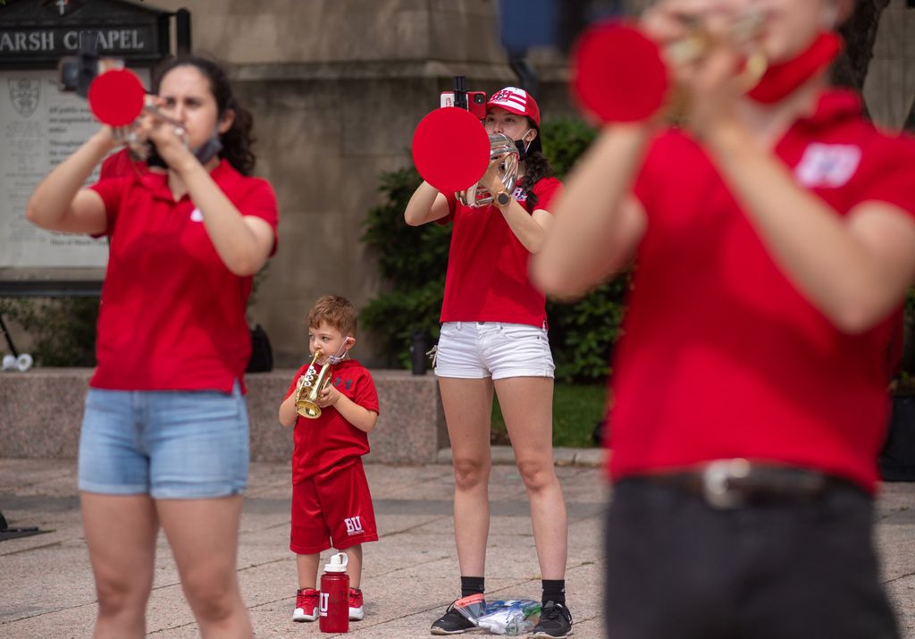 Erika Luetjen (Sargent’22) (center) practicing with fellow BU Pep Band members during a socially distanced pop-up performance on Marsh Plaza on August 25. Possible future Terrier, four-year-old Jacky Perkins, who’d been watching with dad Sam, was invited to play with the band and holds a small trumpet. The instruments with bells are fitted with shields to prevent droplet spread.
