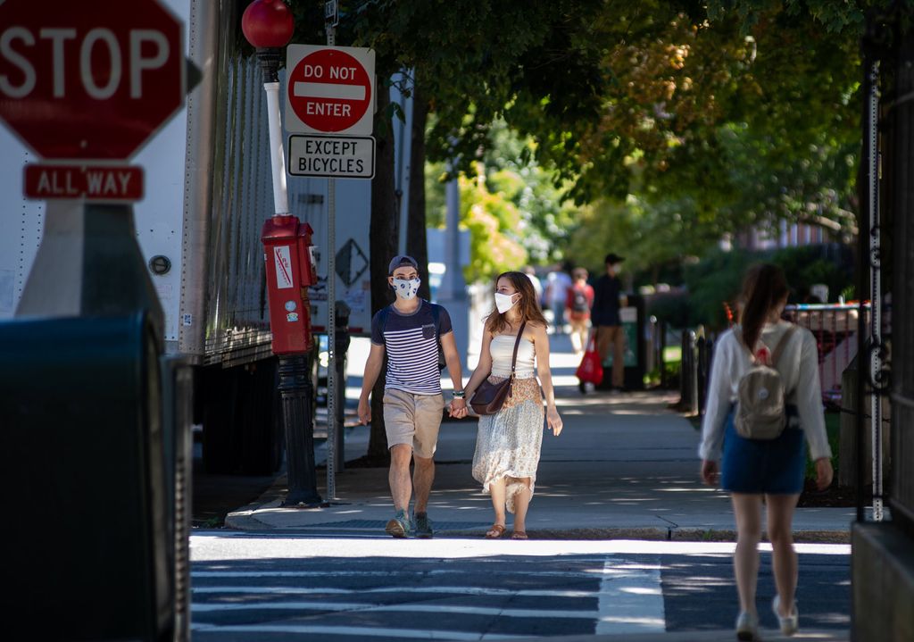 Photo of Meredith Saunders (Questrom’22) (right), and her boyfriend, Clement Mercier, of Cambridge, strolling down Bay State Road on August 30. The couple holds hands as they enter the crosswalk and both wear masks.