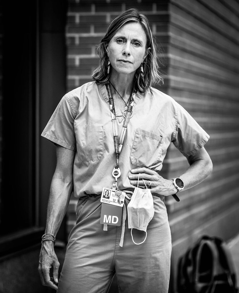 Black and white portrait of Katherine Gergen Barnett, BMC vice chair of primary care innovation and transformation and program director of family medicine, and MED assistant professor of family medicine. She stands in her scrubs with one hand on her hip.