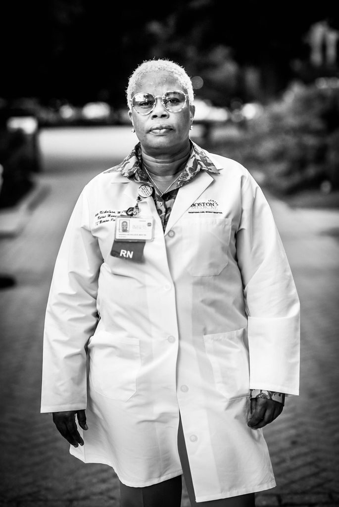 Black and white portrait of Andrea Nicholson, BMC registered nurse with a white lab coat on.