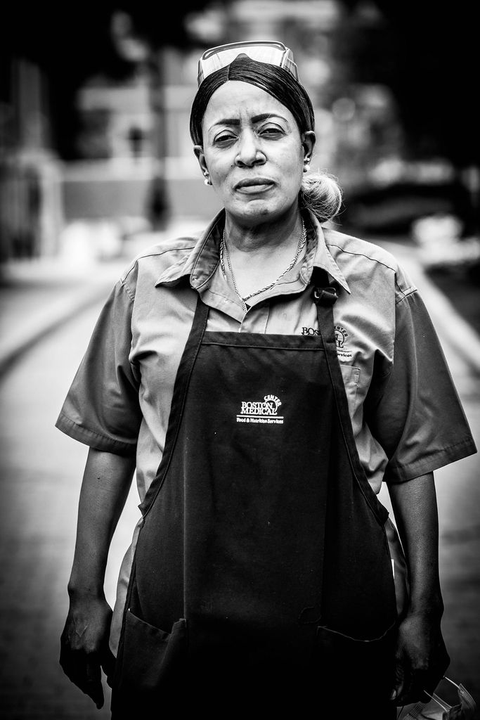 Black and white portrait of Tracey Hanley, BMC food and nutrition services, wearing a BMC apron.