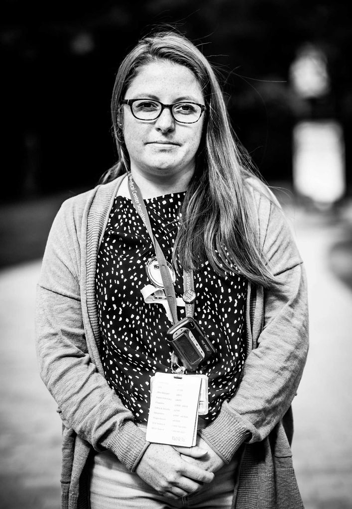 Black and white portrait of Karissa Giovannini, BMC clinical social worker, with her hands held in front of her as she wears her BMC lanyard.