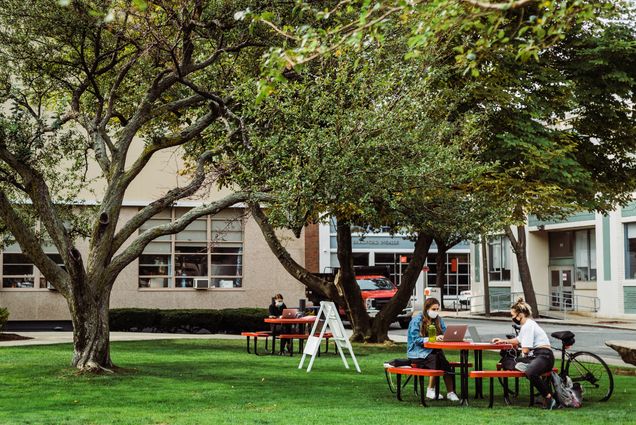 A photo of students sitting together at a table outside the College of Communication