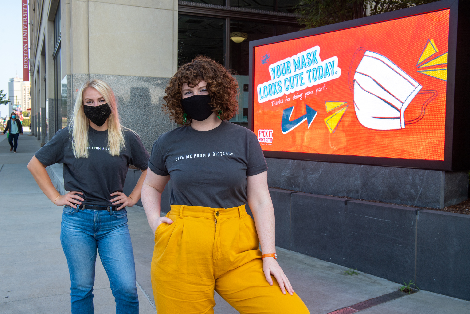 A photo of AdLab leaders Hailey McKee (COM’20), and Hannah Schweitzer (COM’21) in front of one of there campaign displays