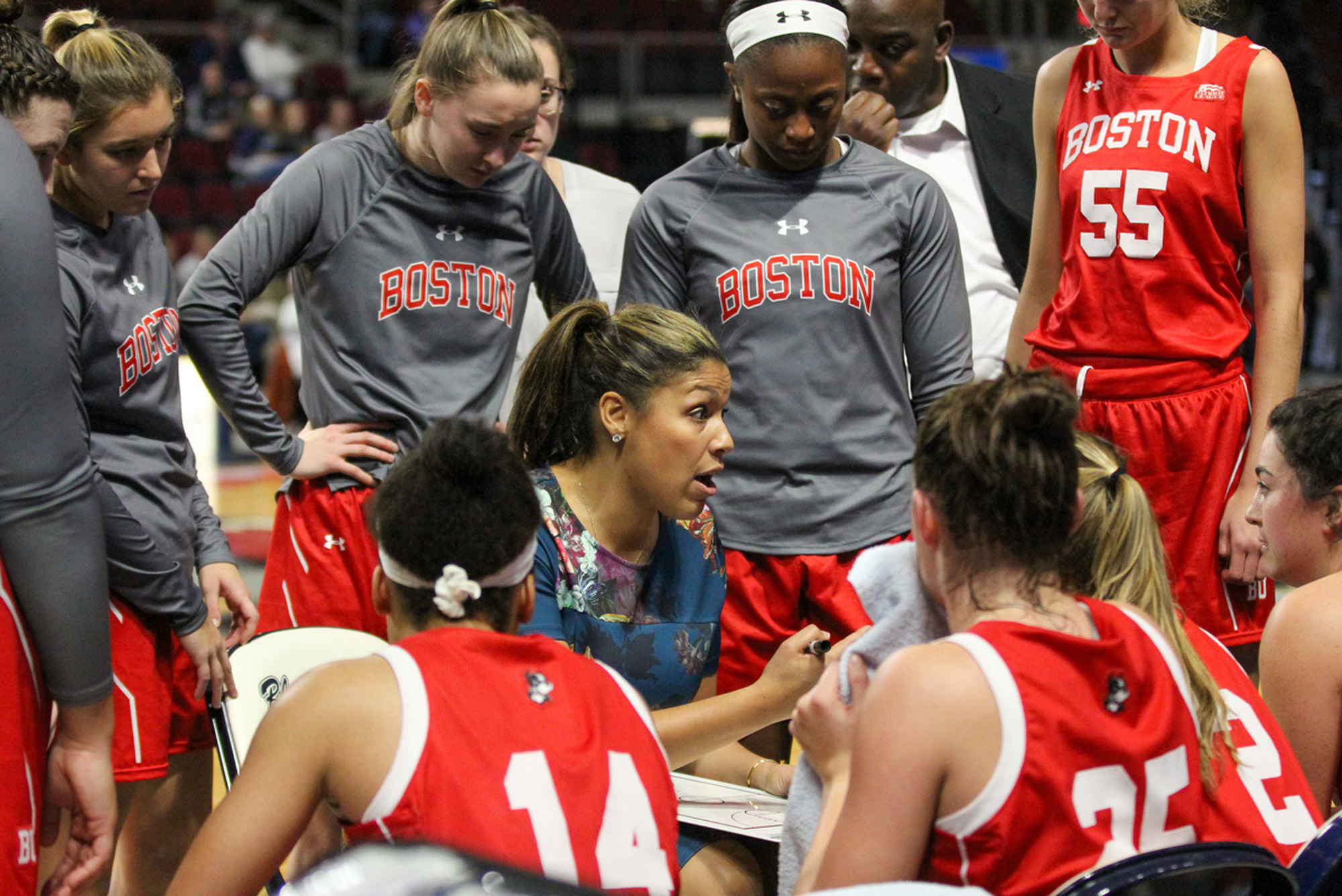 A photo of Marisa Moseley in a huddle with the BU women's basketball team