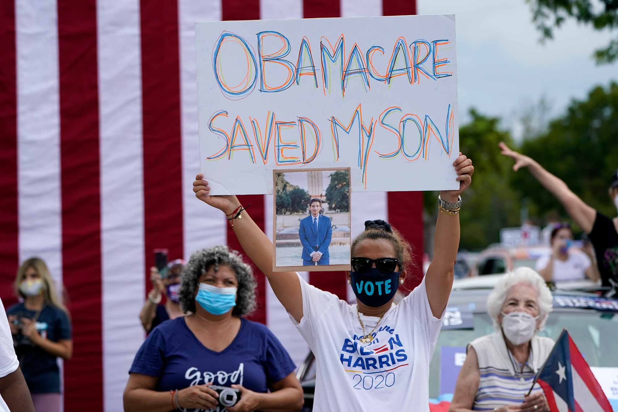 Adelys Ferro holds a sign in support of Obamacare at a Biden/Harris rally in Florida