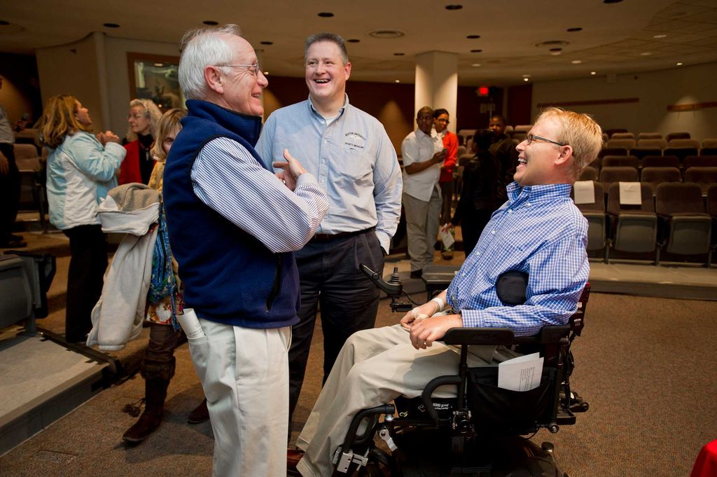 Jack Parker, Larry Venis, and Travis Roy talk after a lecture by Roy at Boston University Sargent College