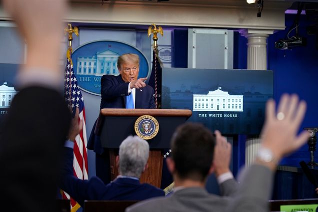 A photo of President Donald Trump taking questions in the White House briefing room
