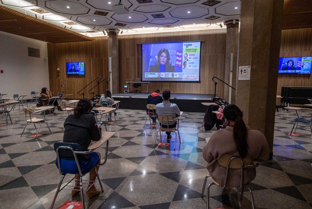 Students watch election night results on multiple screens at the Howard Thurman Center for Common Ground