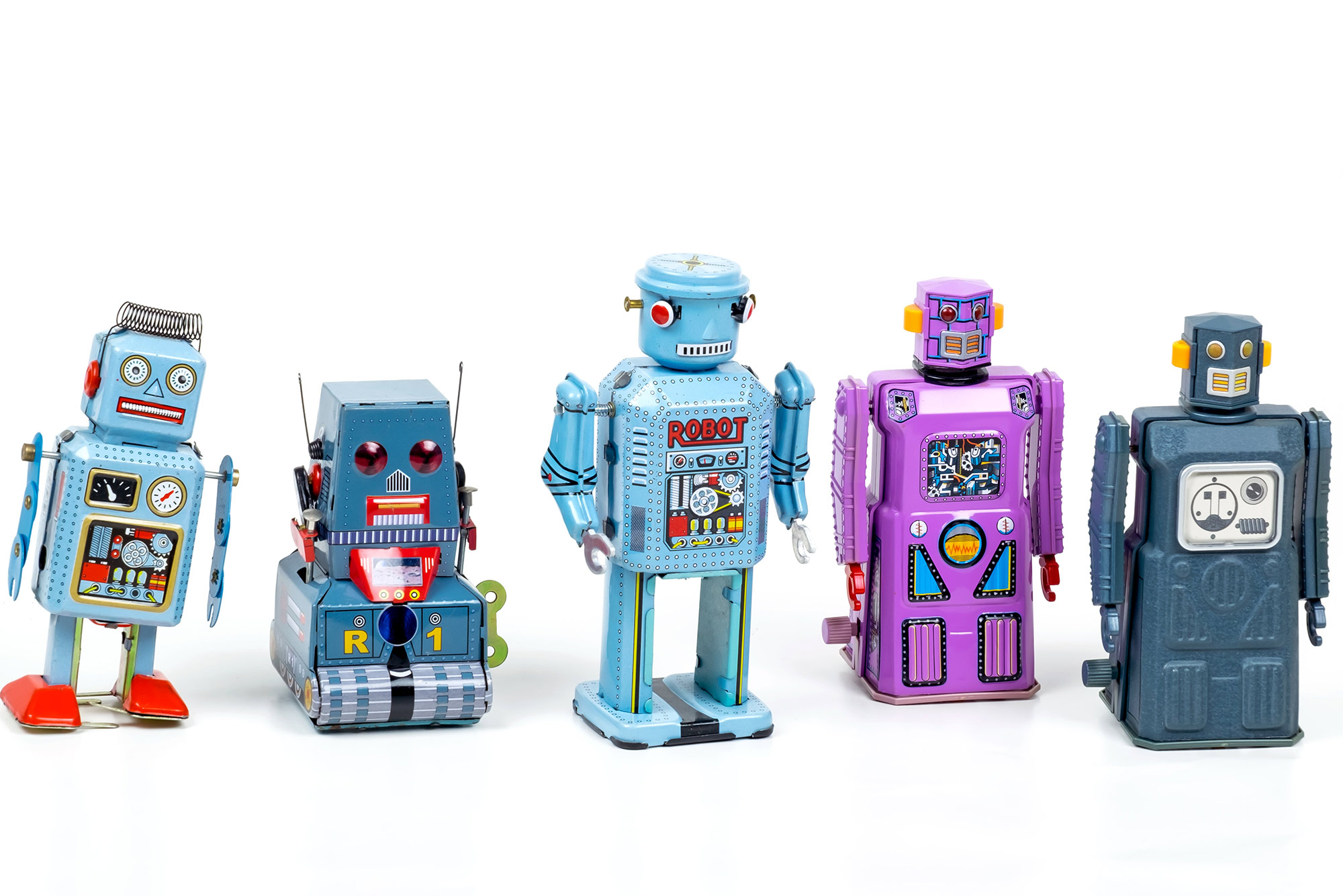 Photo of 5 different toy robots that are blue, light blue and purple, lined up on a white background.