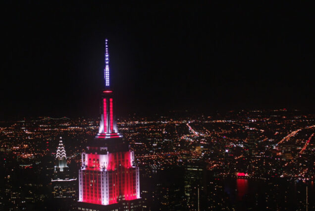 Juengling's lighting work on the Empire State Building. The skyscraper is lit up in red and white.