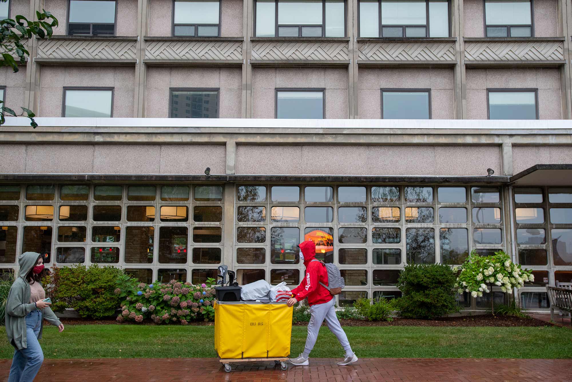 Student pushes their cart of moving items