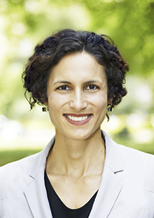 Headshot of Issa Kohler-Hausmann, a Yale Law School professor of law and a Yale associate professor of sociology, with a green, blurred background.