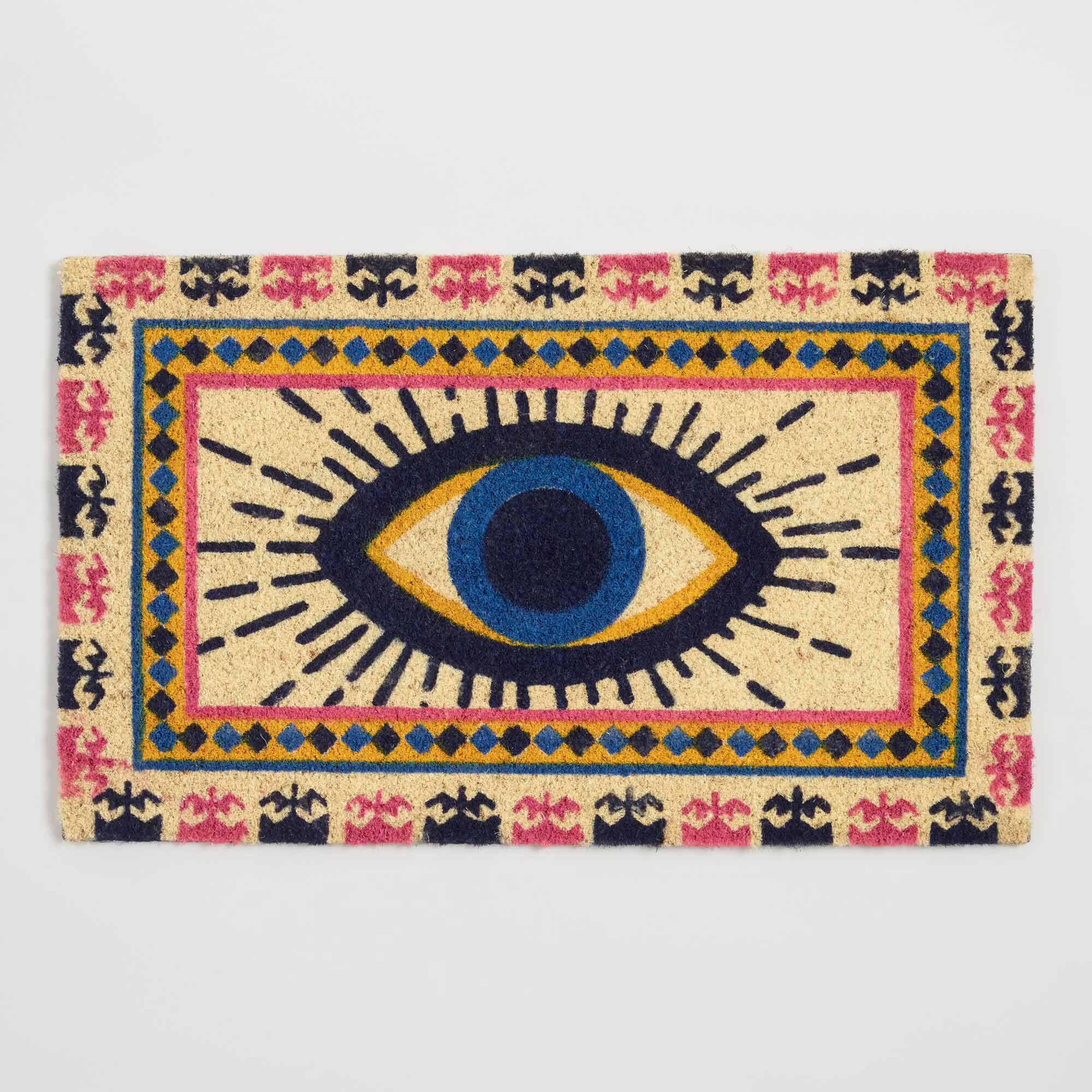 A doormat with a design showing a blue eye and repeating border pattern.