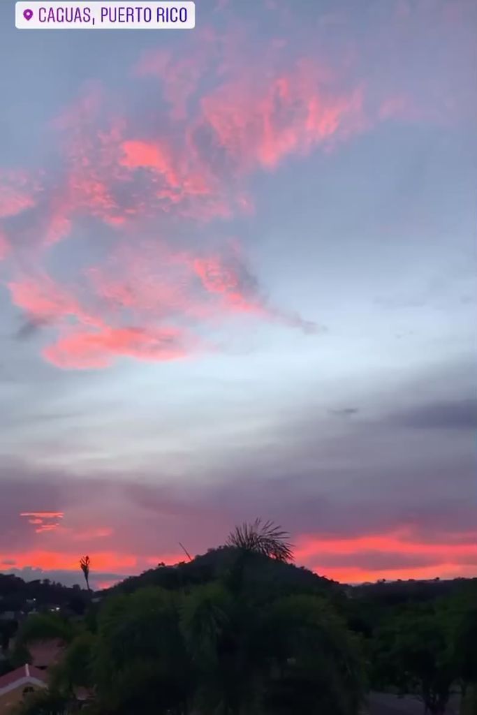 Photo of a sunset with pink clouds over a hill top. An instagram style geographic label reads “Caguas, Puerto Rico”