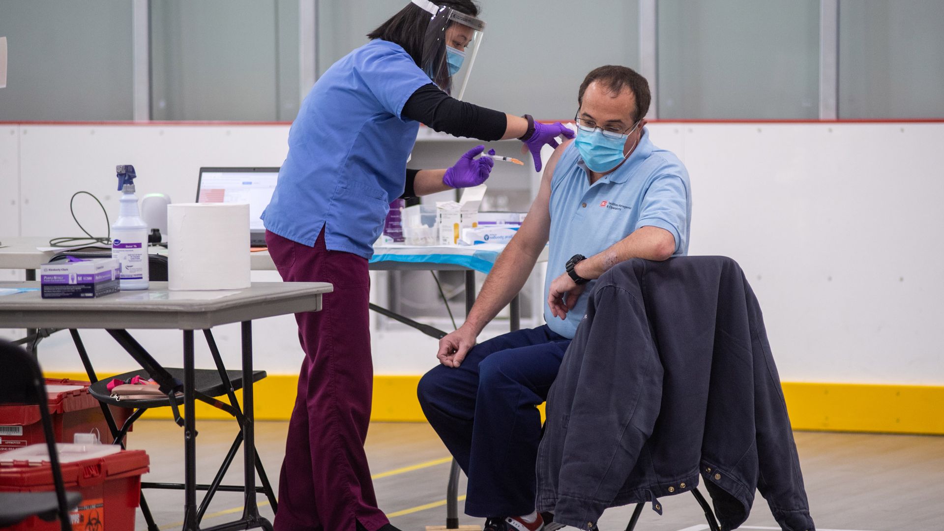 Student Health Services' Shirley Wai, RN, gives lead custodian Antonio Resendes his first dose of the Moderna COVID-19 vaccine January 15 at FitRec.