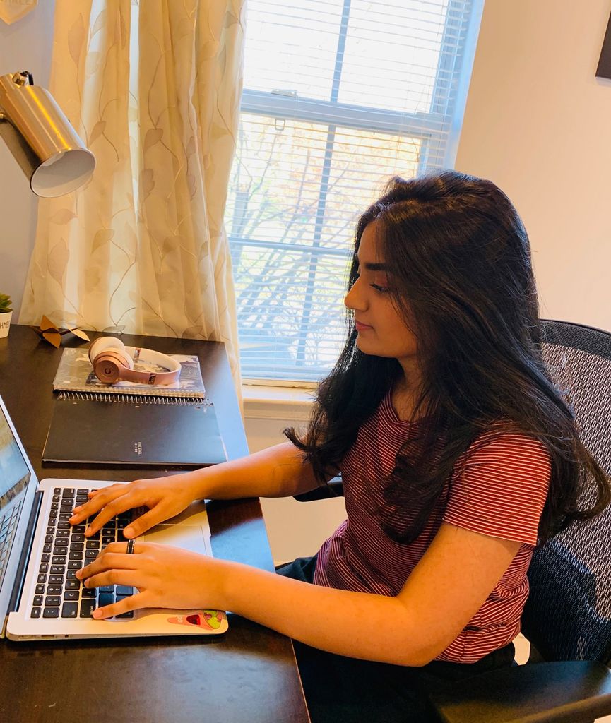 A photo of Sarina Zaparde working at her desk