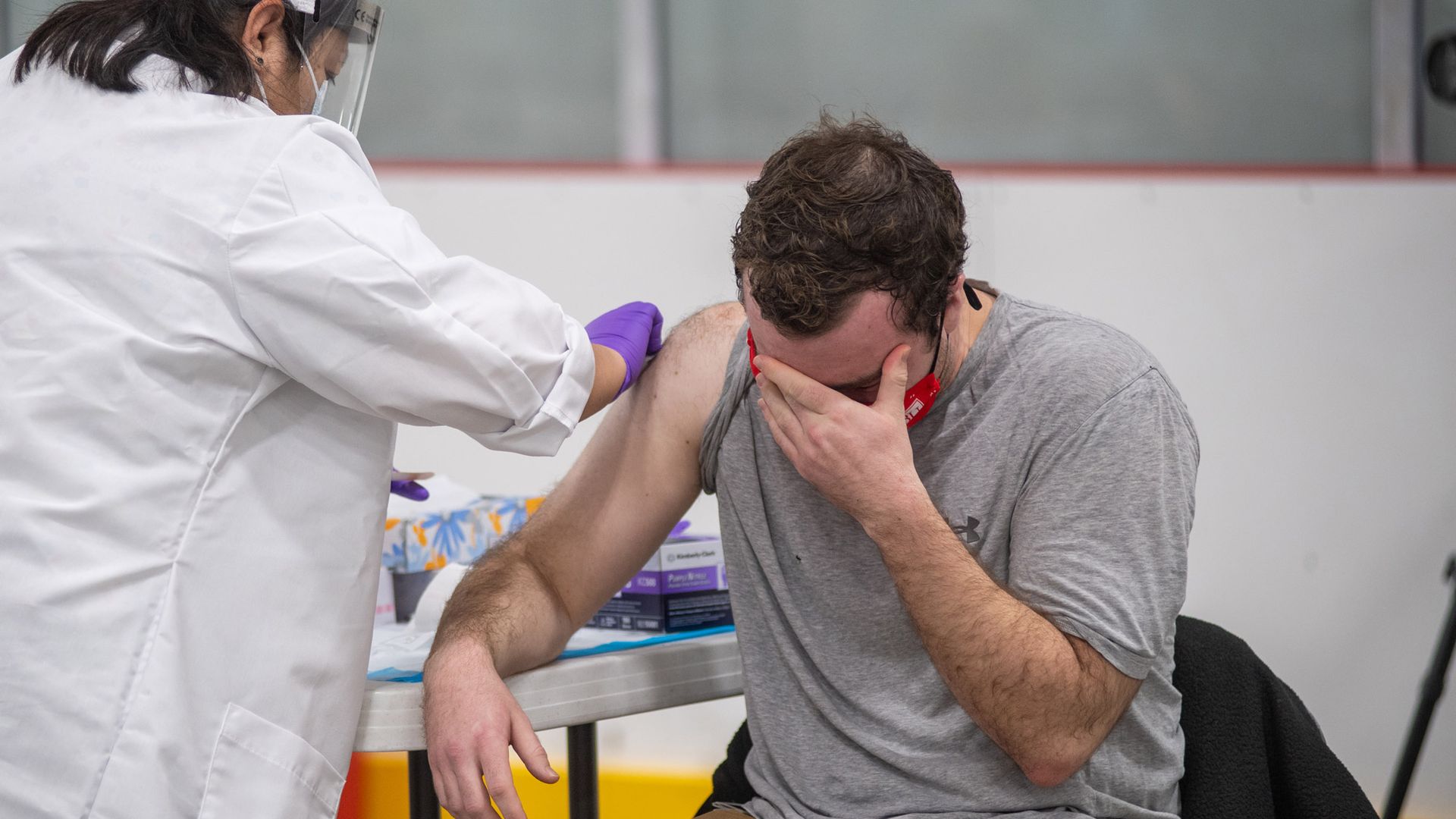 Testing site specialist Luke O’Roark becomes teary-eyed as he receives his first dose of the Moderna COVID-19 vaccine from Student Health services medical assistant Lillian Alves
