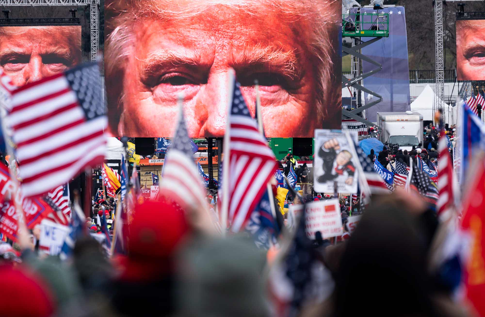 images of donald trump projected on screens at the Save America rally