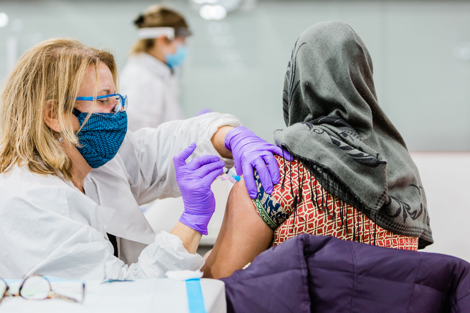 A healthcare worker administers a vaccine to a patient