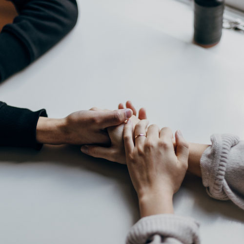 A photo of two people holding hands