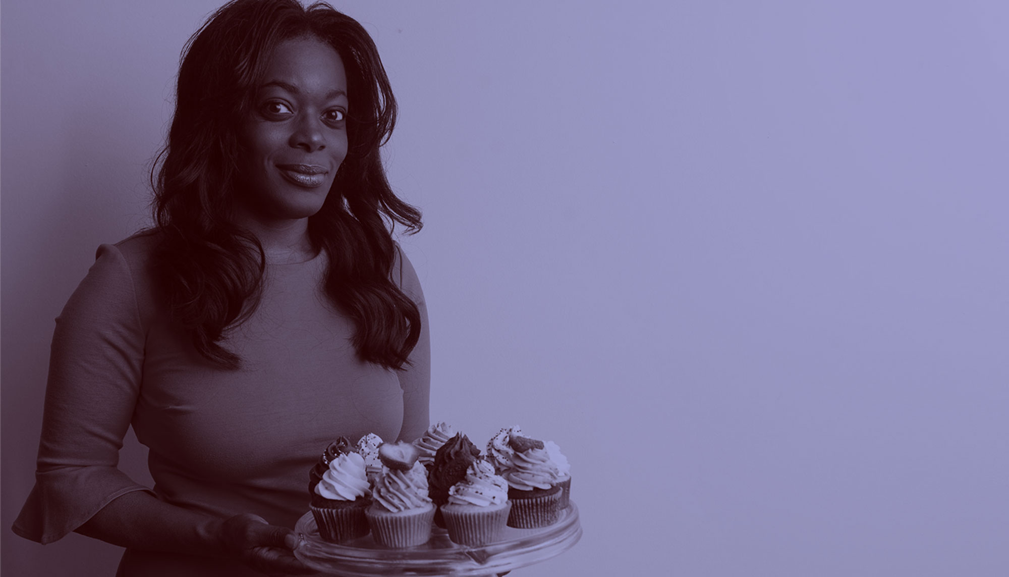 A photo of Shironda White holding a tray of cupcakes. A purple overlay appears over the photo.