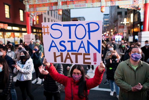 Photo of a female protestor holding a sign that says "#Stop Asian Hate!" Behind her, the entrance to DC's Chinatown is seen. Protesters rallied to call attention to Asian-American discrimination and remember the Asian-American lives lost in a series of shootings last night in Atlanta, in Chinatown, Washington, D.C., on Wednesday, March 17, 2021.