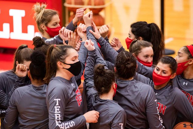 The Boston University Terriers womens basketball team high-five in a pre-game huddle