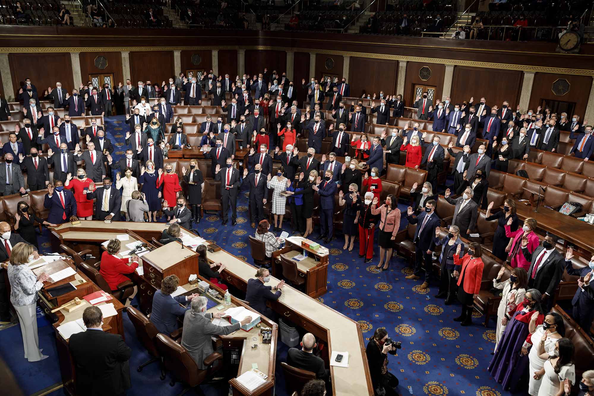 Members of the U.S. House of Representatives wear protective facemasks while being sworn-in by House Speaker Nancy Pelosi (D. California) during the first session of the 117th Congress in the House Chamber in Washington, D.C., U.S., on Sunday, Jan. 3, 2021.