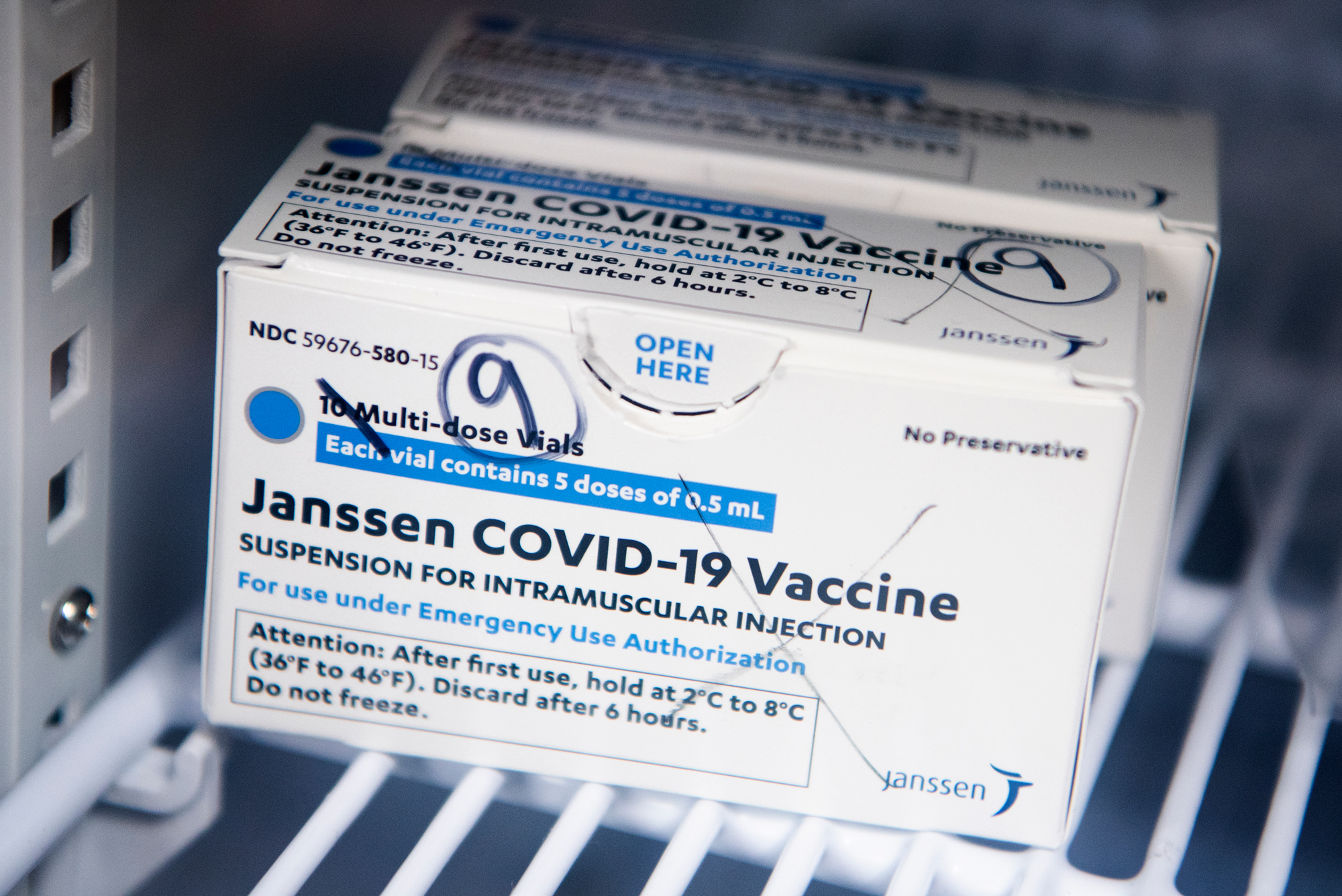 A photo of a box of Johnson and Johnson vaccines sitting on a shelf in a pharmacy