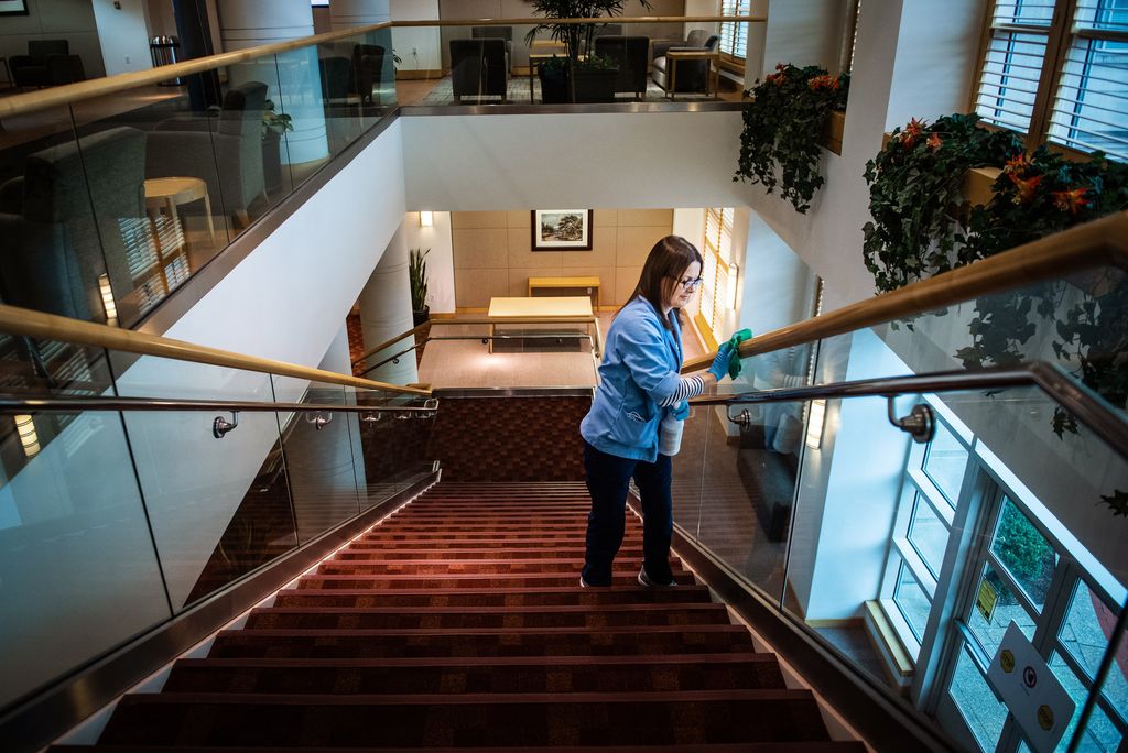 A photo of BU custodian Grace Araujo cleaning a railing.