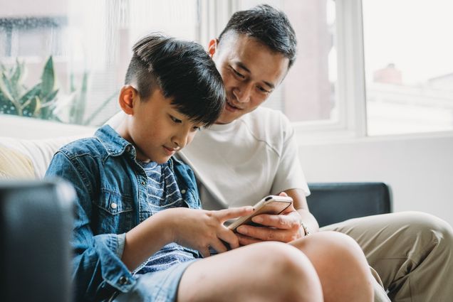 A photo of a father and son working together on a tablet