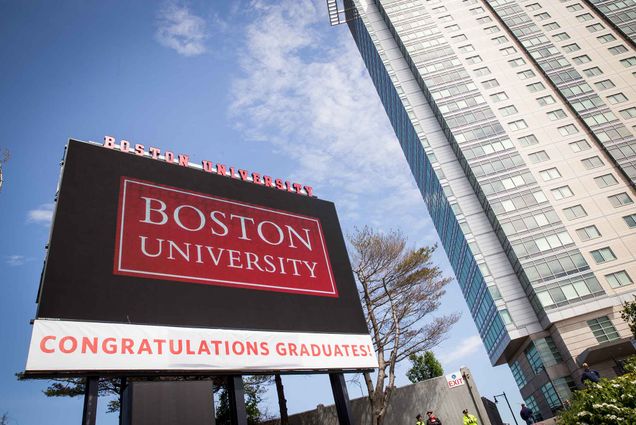 A photo of a digital screen that reads "Boston University. Congrats Graduates!"