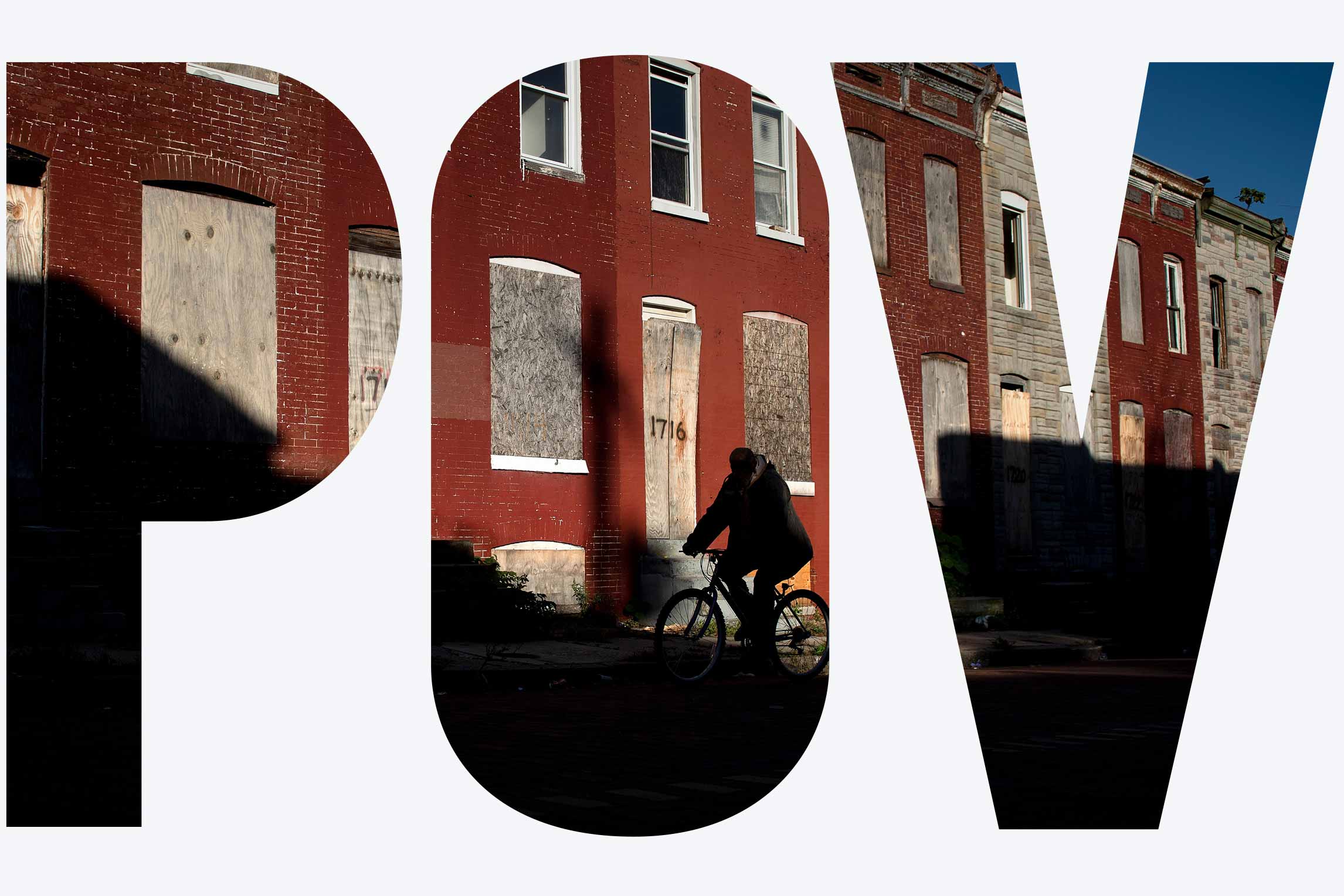 A man rides a bike past boarded up row houses in the Broadway East neighborhood on October 14, 2020, in Baltimore, Maryland.