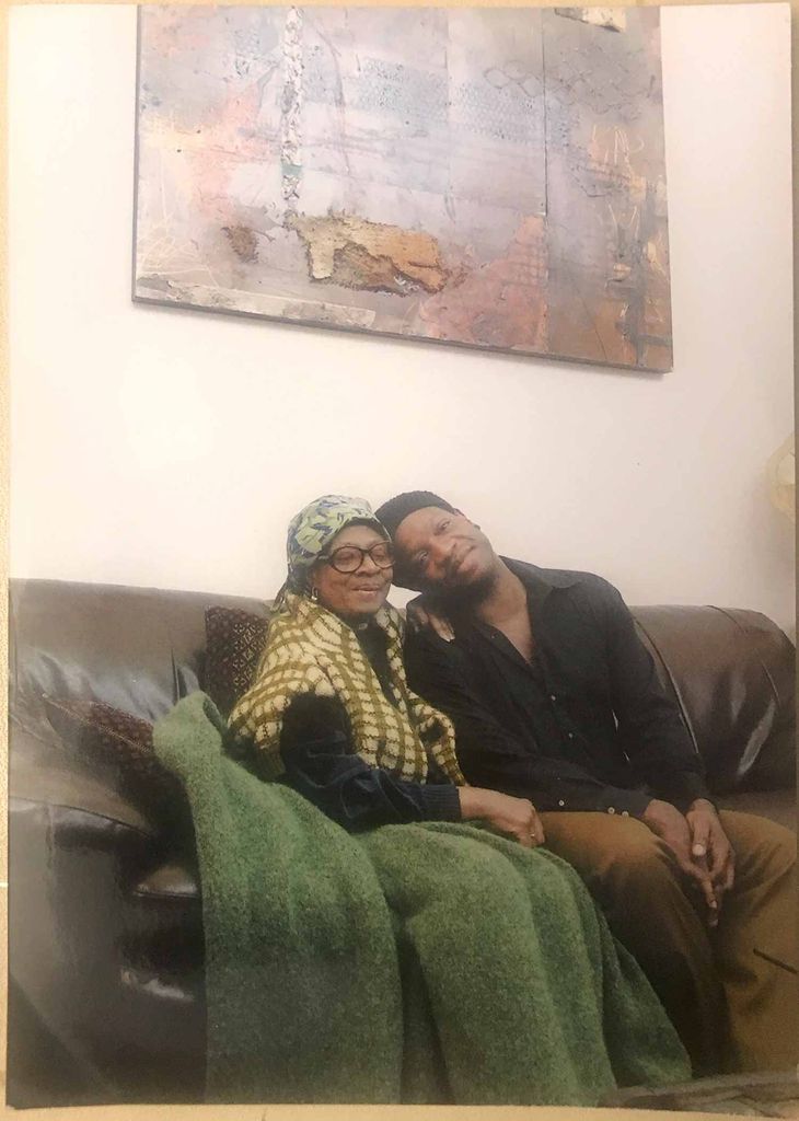 Louis Chude-Sokei sitting on a couch with his mother 