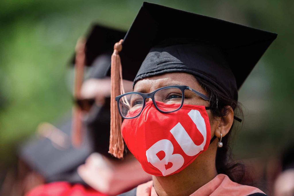 Headshot of a woman graduating senior wearing her mortarbord cap and red BU ppe face mask.