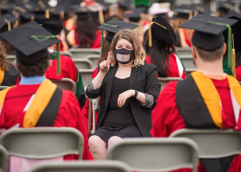 An ASL interpreter signs the Commencement ceremony to Deaf graduates.