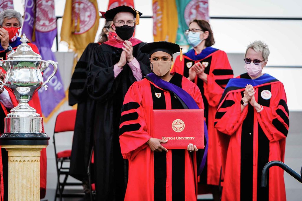 US Representative Ayanna Pressley holds the honorary degree awarded to her during the 2021 BU Commencment.