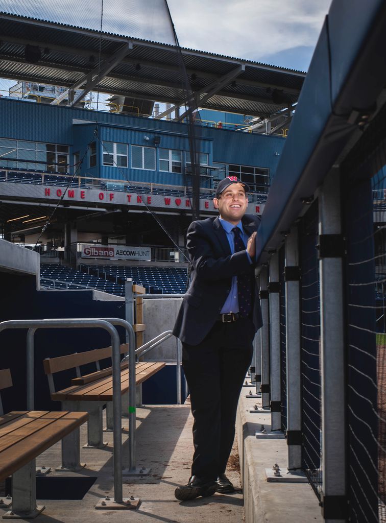 A photo of Matt Levin in the dugout of Polar Park. He is looking out over the field.