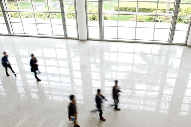 A photo of people walking in the lobby of a building