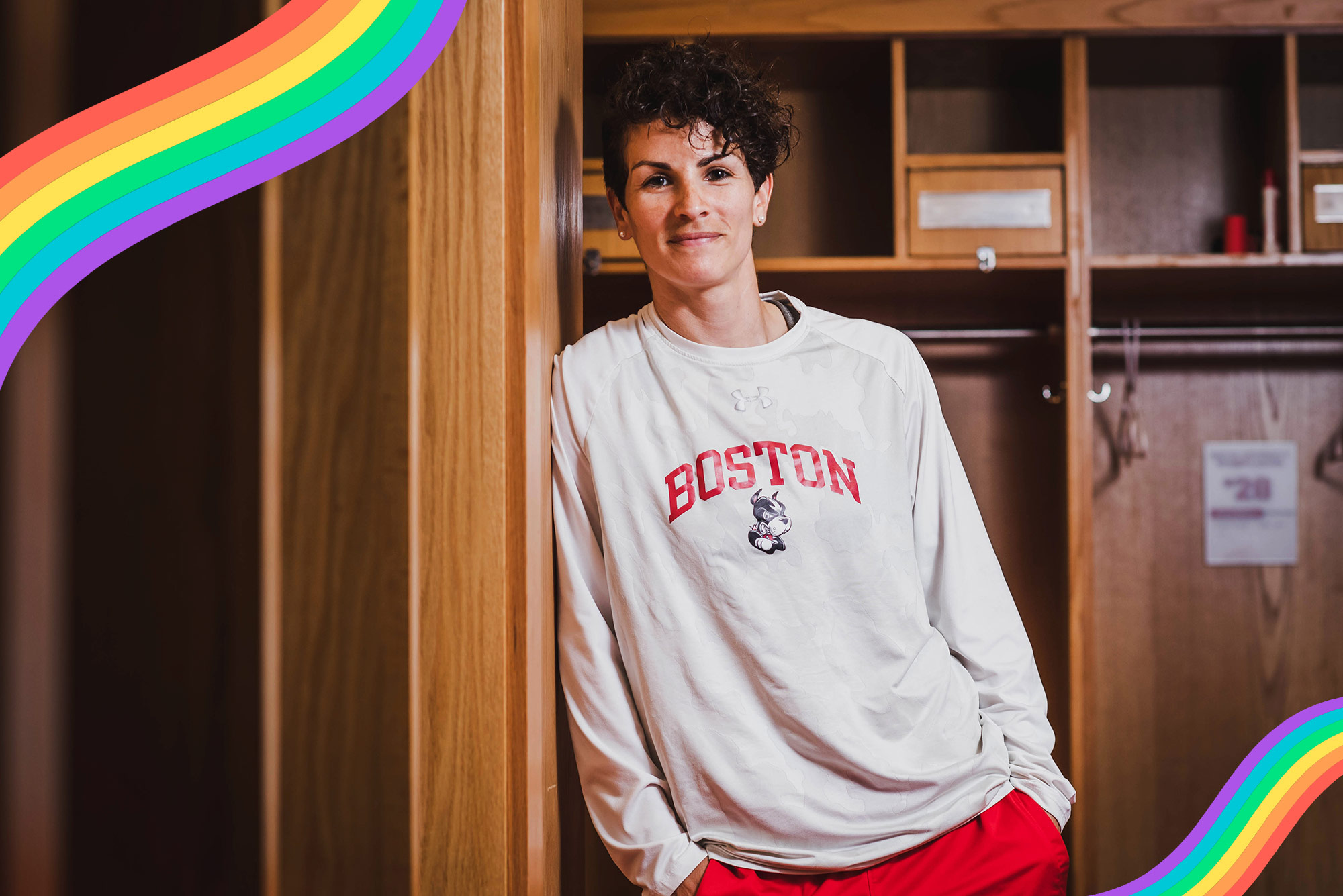 Kelly Lawrence, women’s assistant head soccer coach, poses for a photo on June 19, 2021. She wears a white long sleeve boston university sweatshirt and has her hands in her pockets.