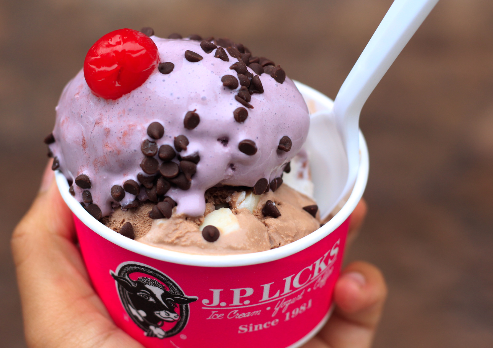 3 scoops of ice cream topped with a cherry in a cup from JP Licks.