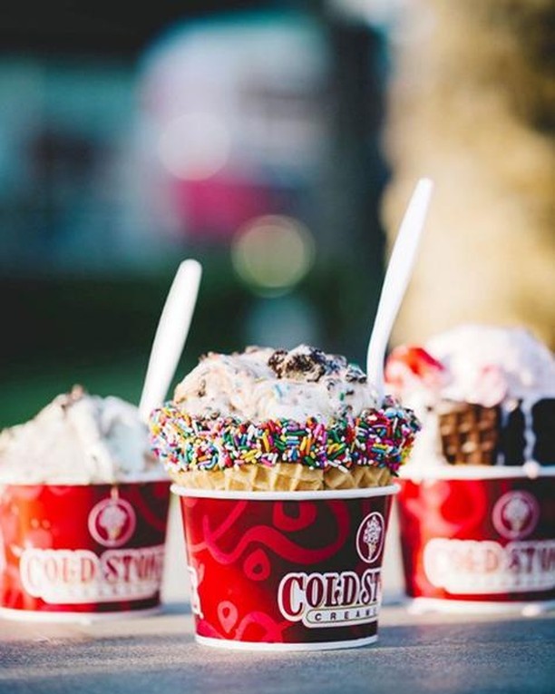 Detail view of three different types of ice cream cups from Cold Stone Creamery sitting on a table.