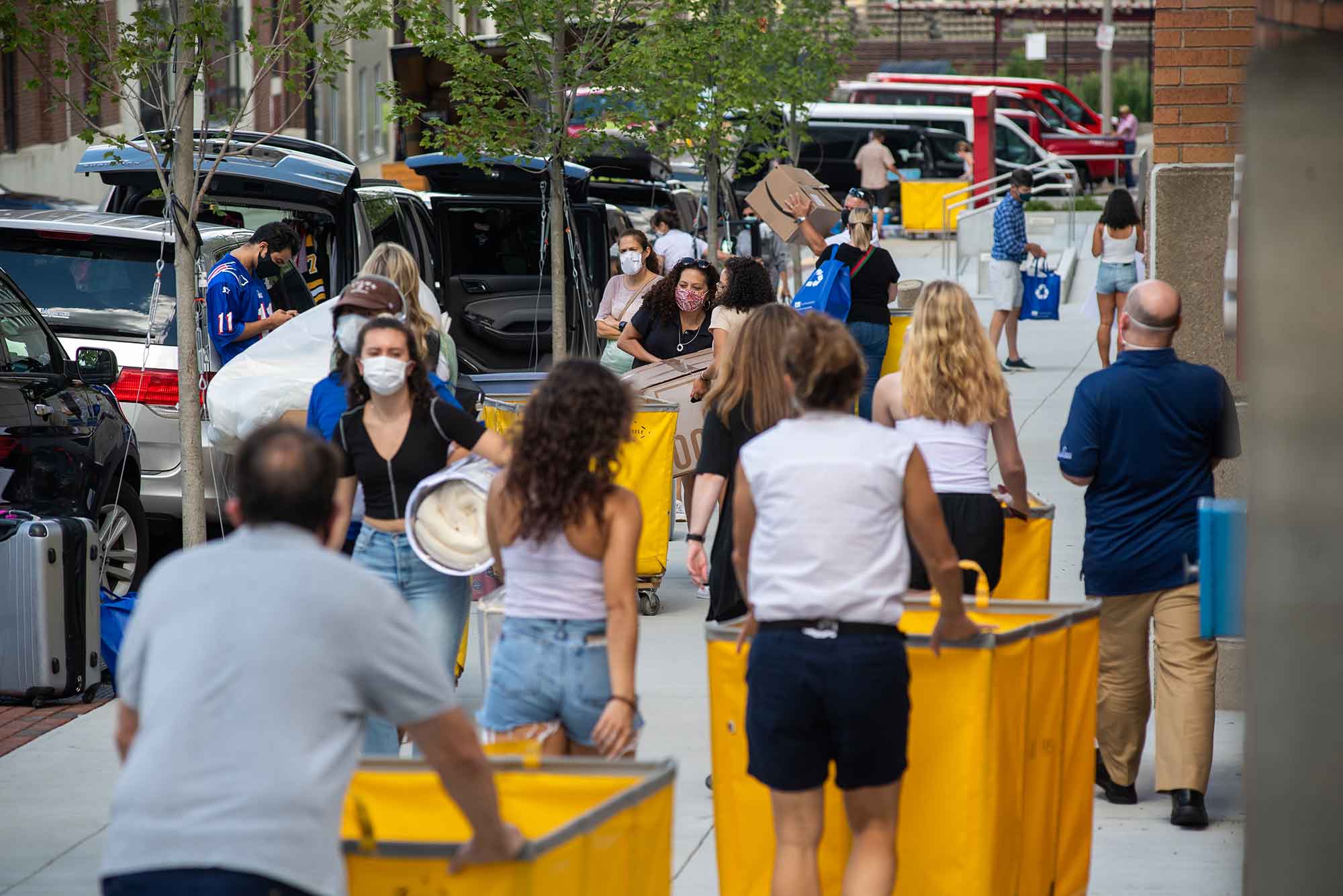 Students and parents wearing protective face masks move into dorms on the Boston University campus, August 2020